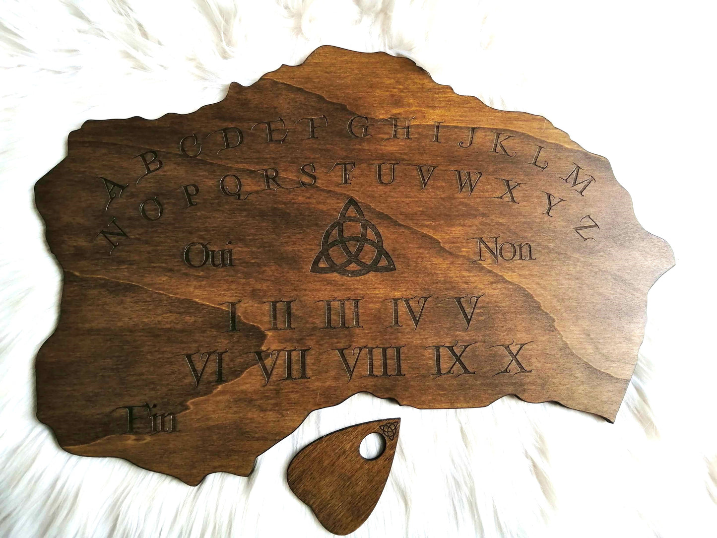 Planche Ouija artisanale réalisée en bois de qualité supérieure, grand format (49cm x 33cm). Chaque planche est unique, façonnée à la main avec un savoir-faire traditionnel. Parfaite pour les séances de divination, le spiritisme ou comme objet décoratif mystique, elle ajoute une touche ésotérique à votre intérieur. Personnalisation disponible sur demande avant l'achat. Fabriquée avec soin en France pour les passionnés des arts occultes et de la spiritualité