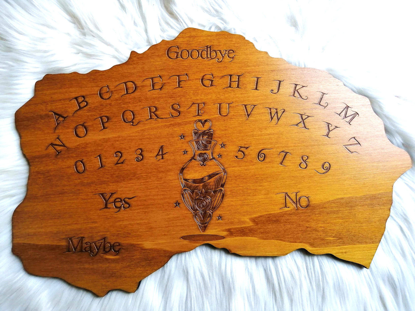 Planche Ouija 'Potion' artisanale en bois de haute qualité, grande taille (49 cm x 33 cm). Chaque planche est soigneusement fabriquée à la main, alliant l'art ésotérique et la qualité artisanale. Parfaite pour les séances de divination, le spiritisme ou comme décoration mystique dans votre espace. Personnalisation possible avant l'achat pour une touche personnelle. Un objet unique pour les passionnés d'arts occultes, fabriqué avec soin en France.