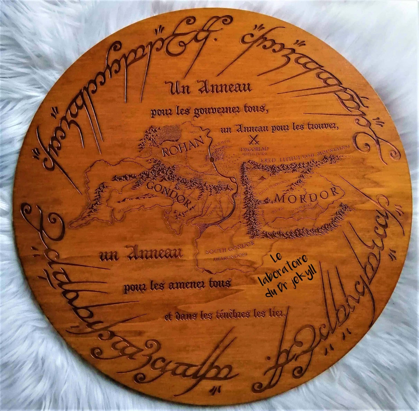 Carte de l'Anneau 'Le Seigneur des Anneaux' en gravure sur bois, réalisée de manière artisanale avec du placage de peuplier (48 cm x 1 cm). Chaque pièce est unique en raison des aspérités et du veinage naturel du bois. Légers contrastes de gravure possibles. Ce produit est vendu avec son attache murale. Un objet de décoration mystique, parfait pour les fans de la Terre du Milieu et de l'univers de Tolkien