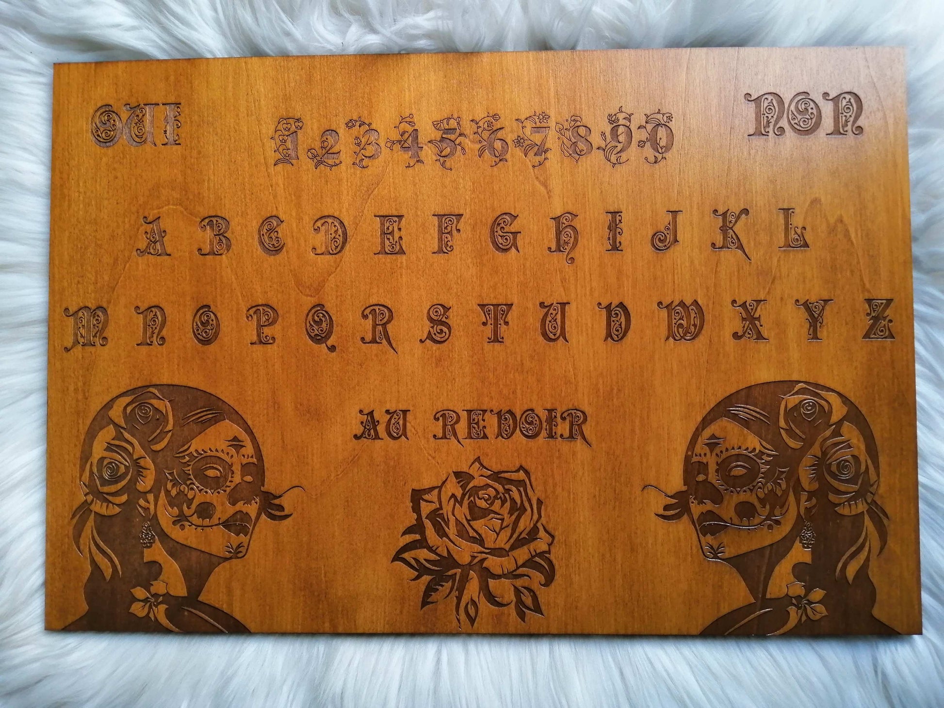 Planche Ouija 'Santa Muerte' artisanale, fabriquée en bois de qualité supérieure (49 cm x 33 cm), alliant artisanat français et art mystique. Chaque pièce est unique, fabriquée à la main avec soin. Idéale pour les séances de divination, le spiritisme, ou comme décoration ésotérique dans votre maison. Personnalisation disponible avant l'achat pour répondre à vos besoins spirituels. Un objet parfait pour les passionnés de l’occulte et de l’art ésotérique.