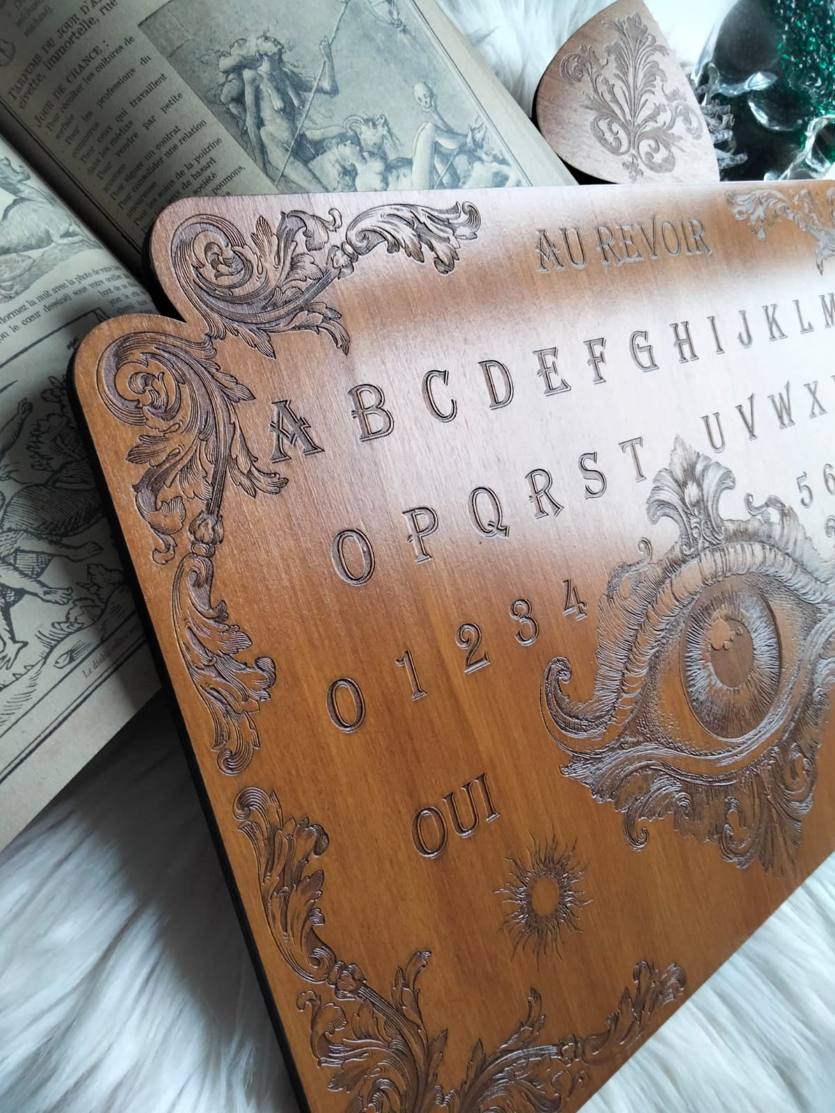 Planche Ouija artisanale et planchette sur fond mystique