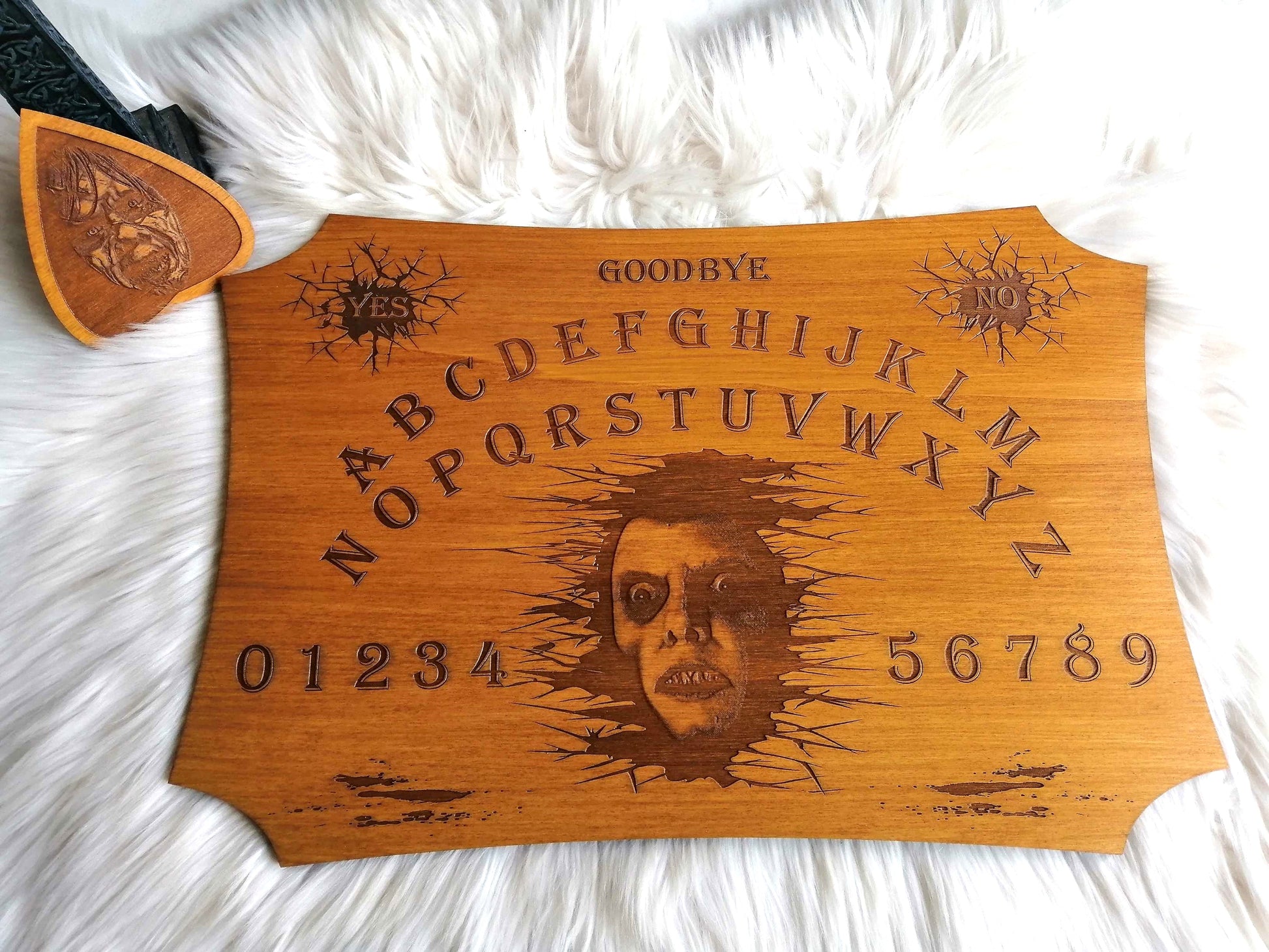 Planche Ouija 'Pazuzu' artisanale, réalisée en bois de qualité supérieure (49 cm x 33 cm). Chaque pièce est fabriquée à la main avec un savoir-faire exceptionnel, inspirée par l'univers de l'Exorciste. Parfaite pour les séances de divination, le spiritisme, ou comme objet décoratif mystique. Personnalisation possible avant l'achat. Un incontournable pour les passionnés d'arts occultes et de spiritualité